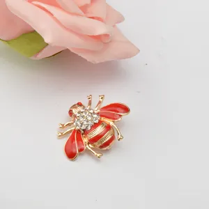 Close-up of a cute rhinestone red enamel bee brooch, stylish insect lapel pin accessory.