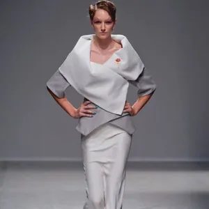 Primer plano detallado de un elegante broche con flor de clavel rojo en la solapa chic.