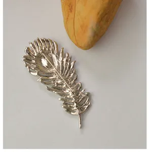 Alloy feather brooch detail view, vintage style clothing accessory for women and men.
