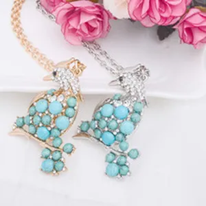 Vue détaillée du collier pendentif oiseau élégant orné de perles turquoise et de cristaux.
