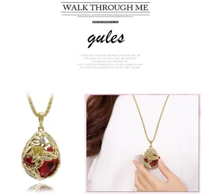 Collier long larme en cristal plaqué or avec des pierres rouges et des motifs floraux.