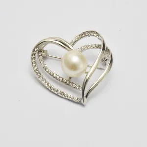Elegant heart-shaped brooch featuring a central pearl and sparkling rhinestones. Perfect for daily wear.