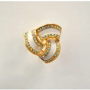 Elegant gold-tone triple ring scarf buckle with shimmering rhinestones and white enamel inlay.