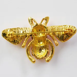 Detailed view of the gold bee brooch back showcasing the pin clasp and textured alloy.