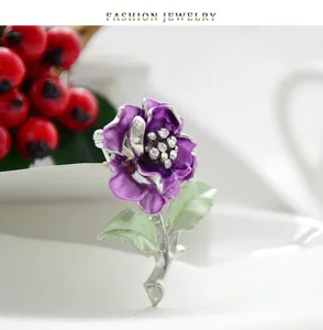 Elegant purple camellia flower brooch pin with sparkling rhinestones and green leaves. Perfect for women.