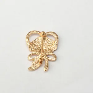 Gold tone alloy brooch back detail, secure pin closure, elegant craftsmanship close up.