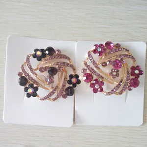 Exquisite rhinestone brooch pins in floral swirl design with vibrant purple and pink crystals.