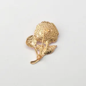 Detail view of the gold tone metal carnation flower brooch back structure and secure pin fastener.