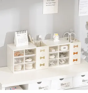 Organizador de escritorio con cajones, compartimentos transparentes y lazo para papelería.
