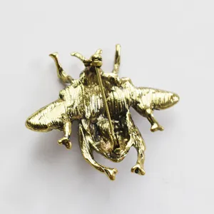 Detailed view of a vintage gold-tone insect brooch pin showing secure clasp mechanism.