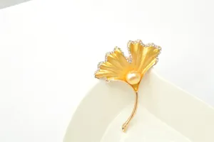 Ginkgo leaf brooch detail, featuring gold-tone metal, faux pearl and rhinestone embellishments.