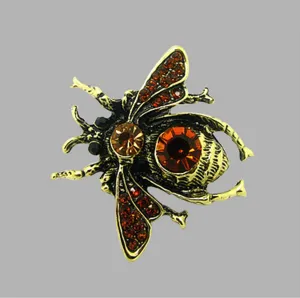 Vintage crystal bee brooch detail showing amber rhinestone insect pin close-up view.