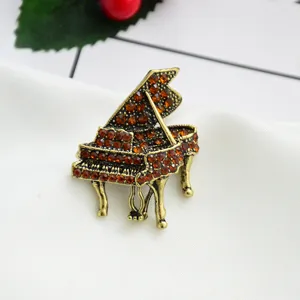 Vintage crystal piano brooch pin for women, elegant musical instrument lapel jewelry badge.