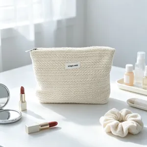 Detailed view of beige woven cosmetic bag with zipper and label, ideal for travel storage.