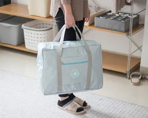 Lightweight light blue travel duffel bag foldable luggage storage bag with sturdy handles.