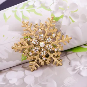 Crystal rhinestone snowflake brooch pin, elegant gold tone winter apparel accessory gift.