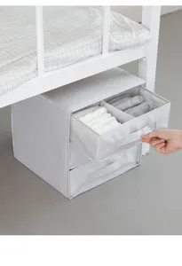Dettaglio del contenitore per biancheria in tessuto con cassetti, scomparti e comoda maniglia.