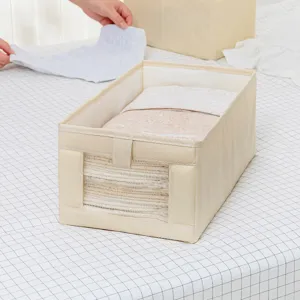Scatola porta abiti in tessuto beige con finestra trasparente per organizzare pantaloni e armadio.