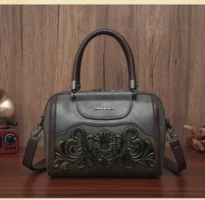 Detailed view of vintage grey retro women handbag with embossed floral pattern and shoulder strap.