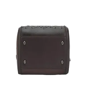 Detail shot of dark brown women's shoulder bag bottom with metal feet and embossed pattern.