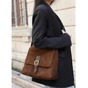 Brown suede retro shoulder bag detail, elegant leather crossbody bag with metal buckle.