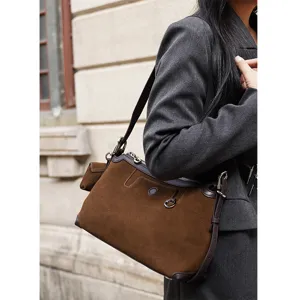 Close-up detail view of retro brown suede shoulder bag, classic autumn fashion daily style.