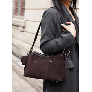 Detailed view of the dark brown suede shoulder bag showcasing exquisite hardware and texture.