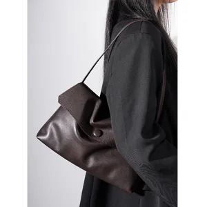 Detail view of the elegant dark brown genuine leather shoulder bag, minimalist design.