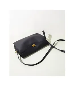 Sac à bandoulière minimaliste en cuir noir avec fermoir doré, accessoire chic quotidien.