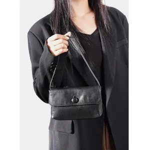 Black genuine leather shoulder handbag detail showing exquisite top handle and flap design.