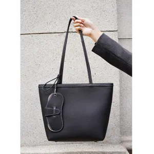 Primer plano del bolso tote negro de piel con finas costuras blancas y detalles finos.