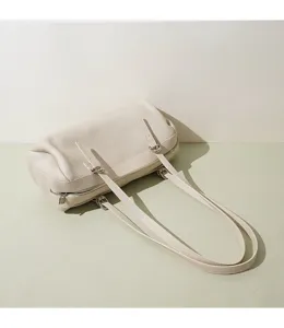 Detaillierte Ansicht der stilvollen beige Leder Boston Umhängetasche mit schmalen Trägern.