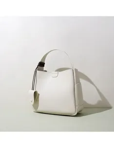 Minimalist white bucket bag detail showing clean leather texture and elegant handle design.