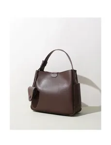 Brown leather bucket shoulder bag detailed view, minimalist commuter handbag with large capacity.