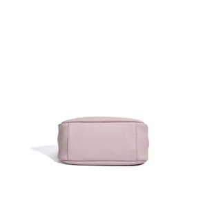 Close-up detail of the flat bottom of a minimalist light purple genuine leather bucket bag.