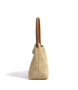 Woven straw bucket bag with brown leather shoulder strap, stylish summer beach handbag.