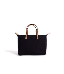 Borsa a mano in tela nera con manici in pelle marrone e design classico per l'uso quotidiano.