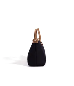Borsa tote in tela nera con manici in pelle marrone, profilo laterale classico per lavoro.
