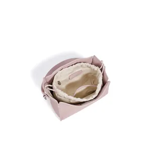 Pink bucket bag with canvas drawstring inner pouch, stylish crossbody designer handbag for women.