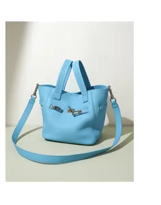 Light blue genuine leather top handle bucket bag with metal lock closure and shoulder strap.