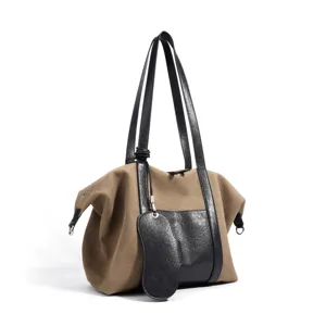 Sac cabas en toile vue de détail, toile marron avec garniture et poignées en cuir noir.