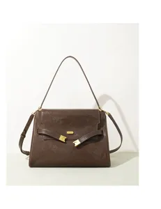 Détail de sac à bandoulière en cuir marron, boucle en métal doré élégante, sac chic