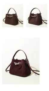 Detailed close-up view of luxury suede handbag featuring metal lock closure and strap details.