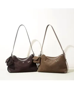 Brown suede shoulder bag detail, vintage underarm bag with side pouch and metal ring accents.