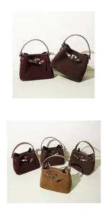 Detailed view of vintage suede handbag with metallic turn-lock closure and elegant handle design.
