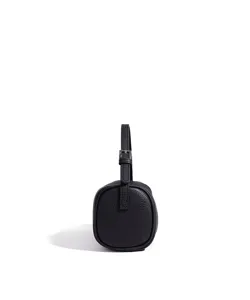 Vue détaillée du sac à main cylindrique en cuir noir montrant le profil et la boucle.