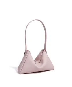 Détail de sac à épaule triangulaire en cuir rose avec fermoir métallique et fine sangle.