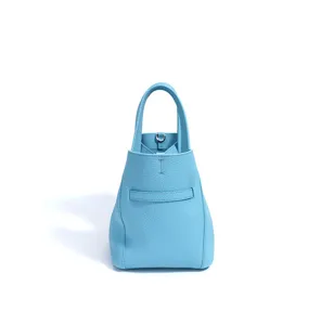 Close up of light blue leather bucket bag detail showing fine texture and hardware loop.