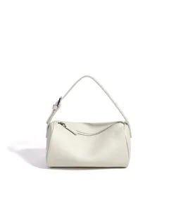 Gros plan sur les détails du sac-tonneau en cuir blanc avec fermeture éclair et boucle.