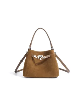 Detailed view of the brown suede bucket bag featuring elegant silver-tone turn-lock hardware.
